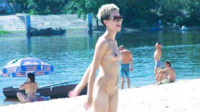 Nude beach girl chats with her friends lays naked and enjoys the sun - hclips